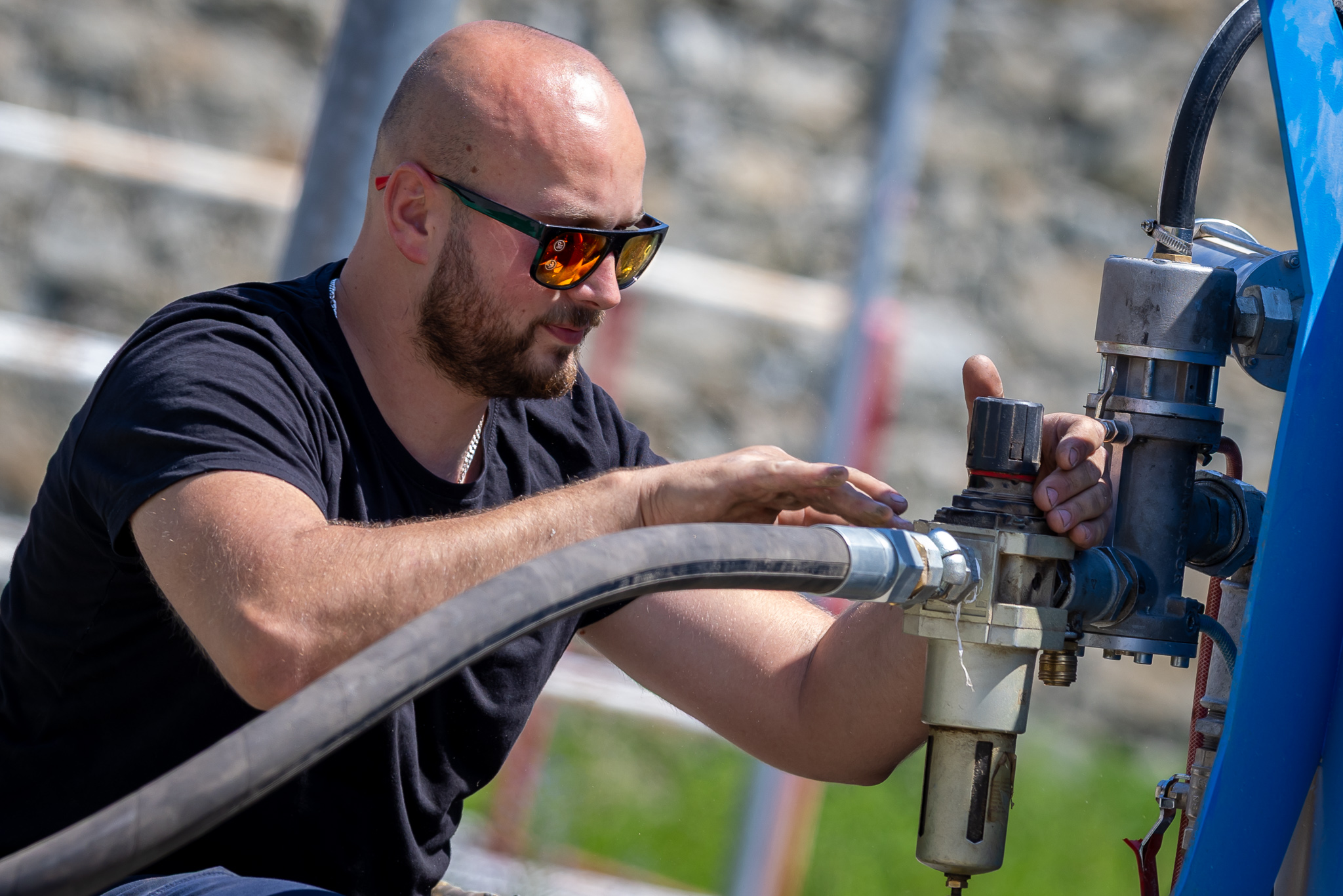 Pieskovač nastavuje pieskovacie zariadenie pri práci v exteriéri
